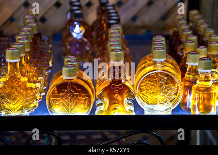 Interessanti forme di sciroppo d'acero bottiglie in vendita da un venditore in Old Montreal. Foto Stock