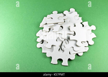 Puzzle di pezzi su sfondo verde Foto Stock