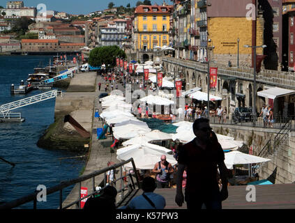 I turisti a piedi passato al fresco e ristoranti dal riverside area nel quartiere vecchio di porto, in Portogallo il 20 agosto 2017. © Giovanni voos Foto Stock