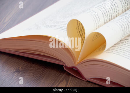 Amore e libri. Forma del cuore fatta dalle pagine del libro Foto Stock