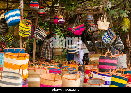Le donne a discutere di borsette in lato strada negozio di vendita di tessuti fatti a mano sisal cesti e borse, Nairobi, Kenia Foto Stock