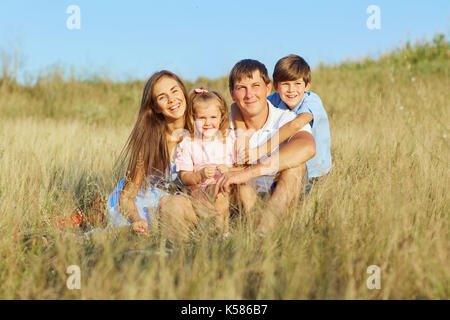 La famiglia felice sulla natura di sorridere e ridere Foto Stock