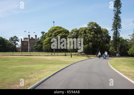 Sydney,NSW, Australia-novembre 20,2016: famiglia a piedi attraverso il Royal Botanic Gardens con la casa del governatore edificio a Sydney in Australia Foto Stock