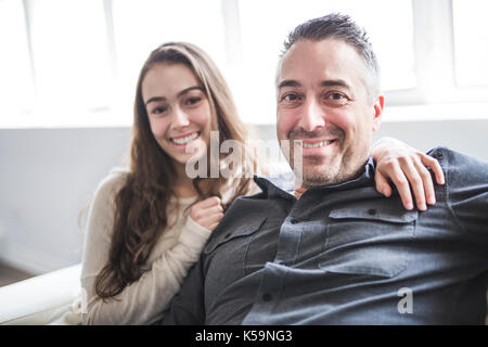 Adolescente ragazza seduta sulla finestra con il padre Foto Stock