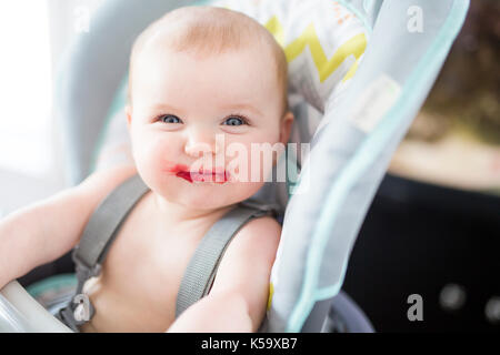 Baby ragazza seduta nel seggiolone per mangiare Foto Stock