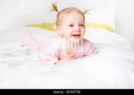 Due anni ragazza bionda nel letto di casa Foto Stock