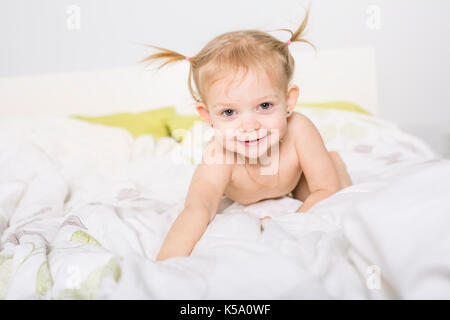 Due anni ragazza bionda nel letto di casa Foto Stock