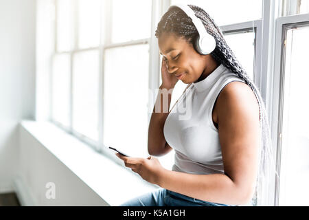 Ragazzi belli americano africano donna ama ascoltare la musica con le cuffie Foto Stock