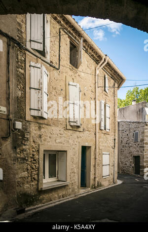 Vecchie case con finestre con persiane, Rue de la Breche, Tourbes, Herault, Francia. Foto Stock