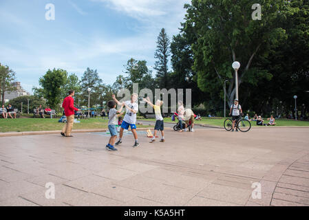 Sydney,NSW, Australia-novembre 20,2016: l'artista di strada con tri-stringa bubble wand e bambini a caccia di bolle in hyde park a Sydney, in Australia. Foto Stock