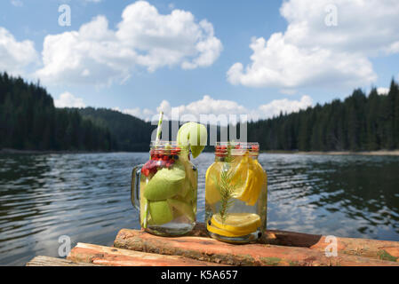 Due vasi di vetro su un molo con acqua infusa Foto Stock