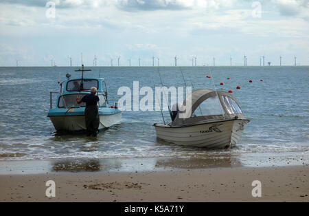 Uomo con piccole barche da pesca a Clacton-on-Sea, England, Regno Unito Foto Stock