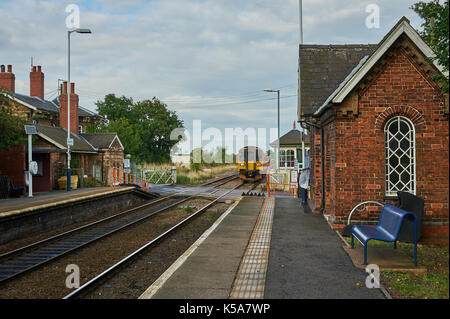 Un passeggero locale treno in avvicinamento rurale stazione ferroviaria di Swinderby in Lincolnshire Foto Stock