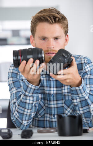 Uomo di pulizia e riparazione di una fotocamera digitale Foto Stock