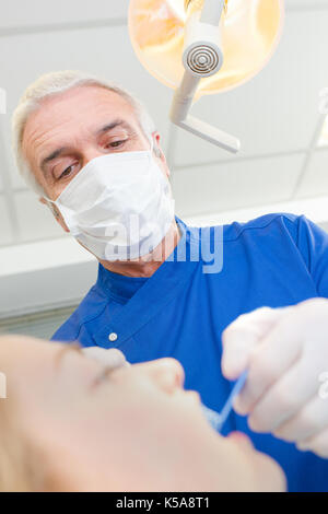 Senior dentista avendo cura di pazienti femmine denti Foto Stock