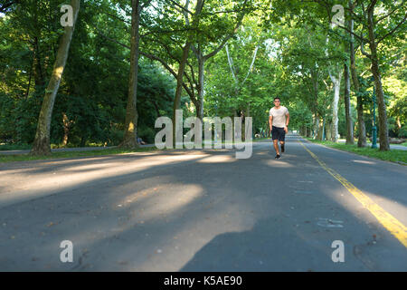 Un bel giovane facendo sport e jogging in un parco. Foto Stock