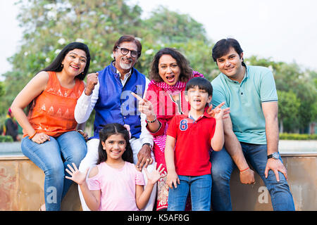 Indian grande famiglia seduta parco di parete avente fun sorridente weekend Foto Stock