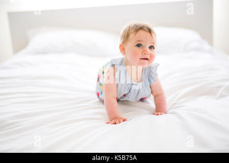 Ritratto di un bambino gattona sul letto nella sua camera da letto Foto Stock
