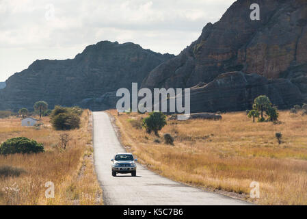 Strada che corre lungo la formazioni di arenaria che fuoriescono dalla prateria, Isalo National Park, Madagascar Foto Stock