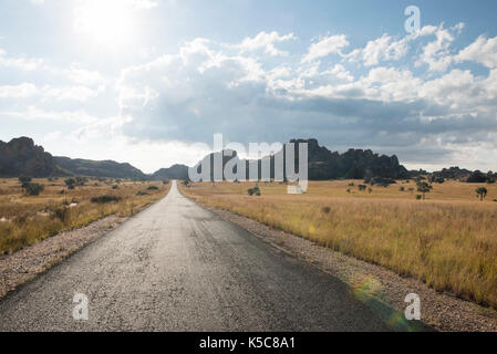 Strada che corre lungo la formazioni di arenaria che fuoriescono dalla prateria, Isalo National Park, Madagascar Foto Stock