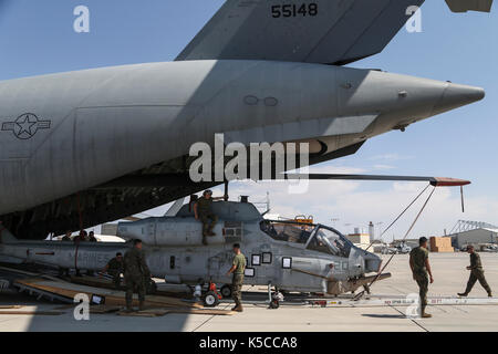 Stati Uniti Marines con Marine Attacco leggero elicottero Squadron 367 (HMLA-367) un offload AH-1W Super Cobra da un C-17 Globemaster III Foto Stock