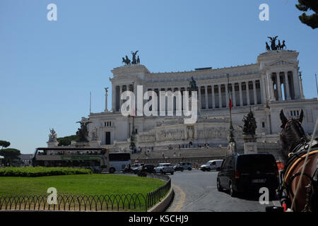 Un carro trainato da cavalli prende toursts lungo vittorio emanuele monumento in italia a Roma il 5 luglio 2016. Foto Stock