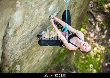 Giovane donna principiante arrampicata su roccia verticale, vista da sopra Foto Stock