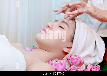 Giovane donna asiatica la ricezione di argilla maschera facciale a spa e salone di bellezza Foto Stock