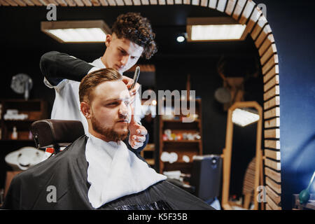 Uomini acconciature e taglio di capelli in un negozio di barbiere o parrucchiere. Foto Stock