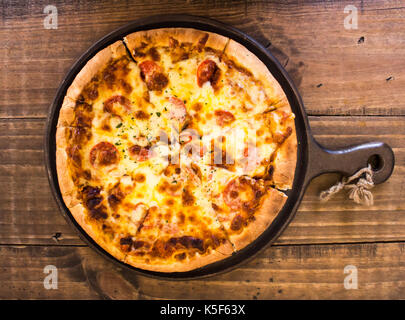 Salsiccia per pizza pizza pasto servito nella coppa sul tavolo di legno Foto Stock