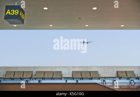 Airport lounge di partenza, aereo nell'sfondo sfocato, vacanze estive concetto, terminale di un aeroporto area di attesa Foto Stock