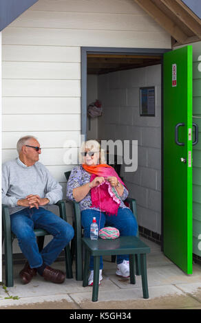 Swanage, Dorset, Regno Unito. 9 Sep, 2017. Regno Unito meteo: heavy rain e tuoni, intervallati da sole a Swanage. Coppia matura al di fuori seduta beach hut con la donna maglia. Credito: Carolyn Jenkins/Alamy Live News Foto Stock