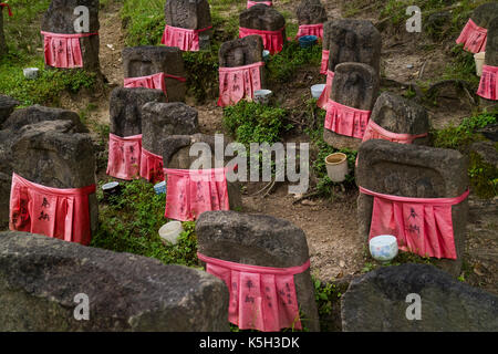 Nara - Giappone, 30 maggio 2017: pietra pacifica relegious jizo statue con red gonne in giardino Foto Stock