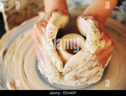 Mani lavorando sulla ruota in ceramica Foto Stock