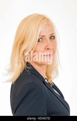 Ritratto laterale testa e spalle di una donna bionda di mezza età nel blazer scuro isolato su bianco. Foto Stock