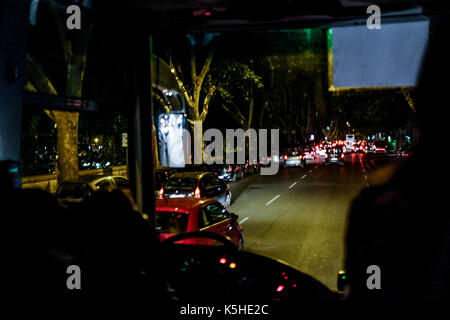 Gli autobus, automobili e motociclette e scooters lotta per lo spazio durante il traffico di notte ad Atene, Roma il 23 settembre 2017. Foto Stock