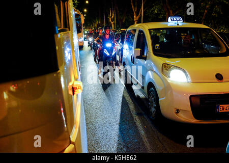 Gli autobus, automobili e motociclette e scooters lotta per lo spazio durante il traffico di notte ad Atene, Roma il 23 settembre 2017. Foto Stock