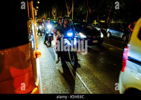 Gli autobus, automobili e motociclette e scooters lotta per lo spazio durante il traffico di notte ad Atene, Roma il 23 settembre 2017. Foto Stock