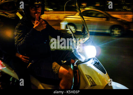 Gli autobus, automobili e motociclette e scooters lotta per lo spazio durante il traffico di notte ad Atene, Roma il 23 settembre 2017. Foto Stock