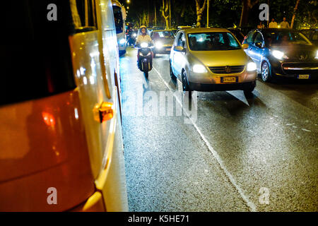 Gli autobus, automobili e motociclette e scooters lotta per lo spazio durante il traffico di notte ad Atene, Roma il 23 settembre 2017. Foto Stock