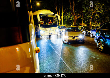 Gli autobus, automobili e motociclette e scooters lotta per lo spazio durante il traffico di notte ad Atene, Roma il 23 settembre 2017. Foto Stock