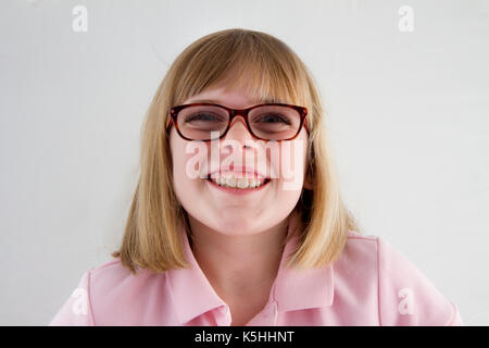 Ragazza giovane nella sua uniforme scolastica sorridente verso la telecamera Foto Stock