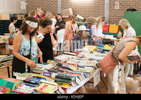 Le mamme delle scuole femminili sfogliano libri usati e usati in vendita in una festa scolastica australiana a Sydney, nuovo Galles del Sud, Australia Foto Stock