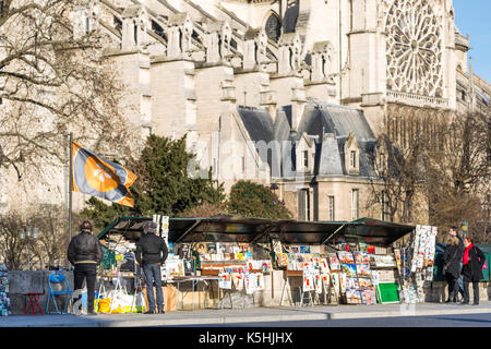 Pedoni di Fronte ausati (bouquinistes) con la cattedrale di Notre dame dietro, Parigi, Francia Foto Stock