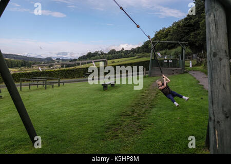 Ragazza divertirsi sul filo di zip in gioco adventure park di Denny, SCOZIA Foto Stock