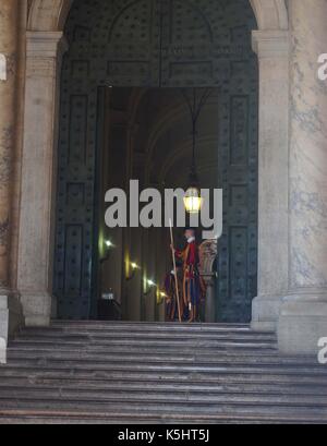 Un membro della Guardia Svizzera sorge l attenzione in ingresso alla Basilica di San Pietro e la Città del Vaticano, Roma Foto Stock