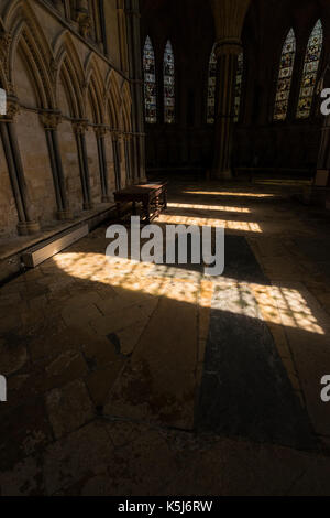 La luce del sole attraverso le finestre di vetro macchiate gettando ombre sulla pietra contrassegnato il pavimento della casa del Capitolo, Cattedrale di Lincoln, Lincoln city, lincolnsh Foto Stock