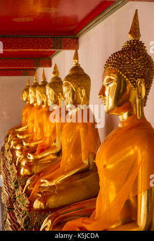Fila di seduta statue di Buddha all'interno di Wat Pho o il Tempio del Buddha reclinato, bangkok, Thailandia Foto Stock