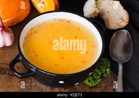 Crema di zucca minestra con peperoncino rosso in ciotola. primo piano. autunno comfort food Foto Stock