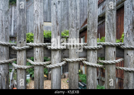 Giardino in legno recinto legati insieme con corda spiovente Foto Stock